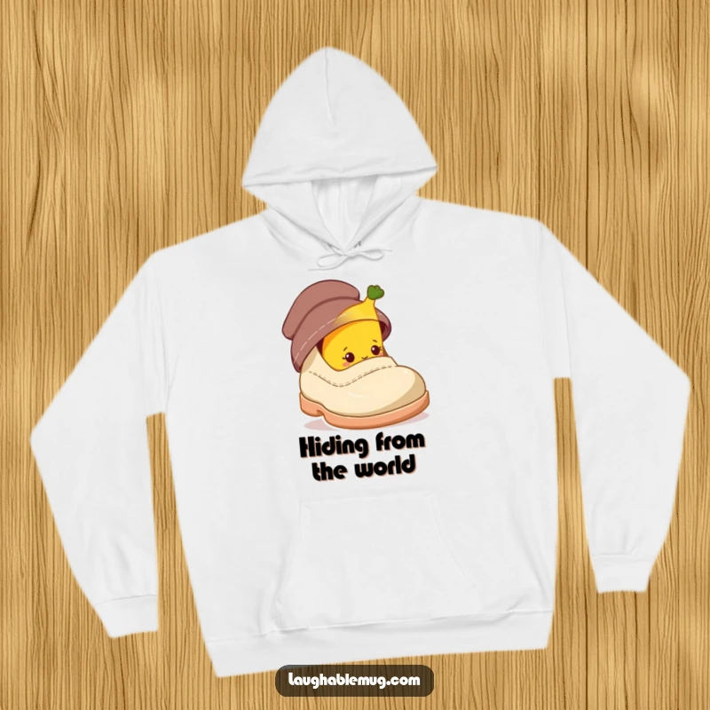 Funny hoodie with a shy banana character peeking from behind a giant shoe, perfect for cozy hiding.