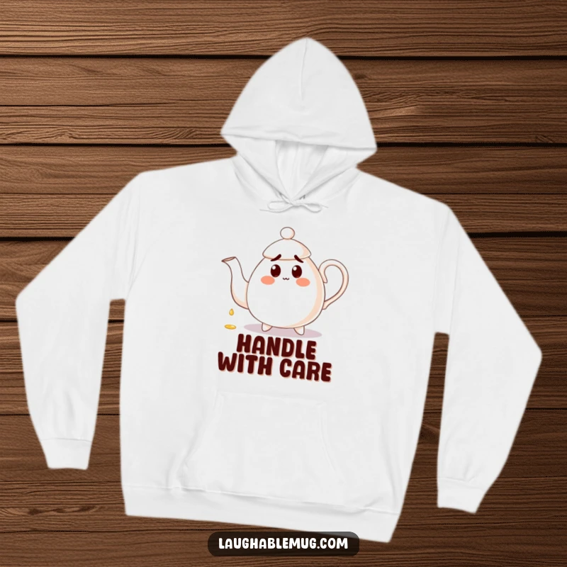 Funny Hoodie: A surprised teapot spills tea onto its own handle, embodying a comical and cozy design for lounging.